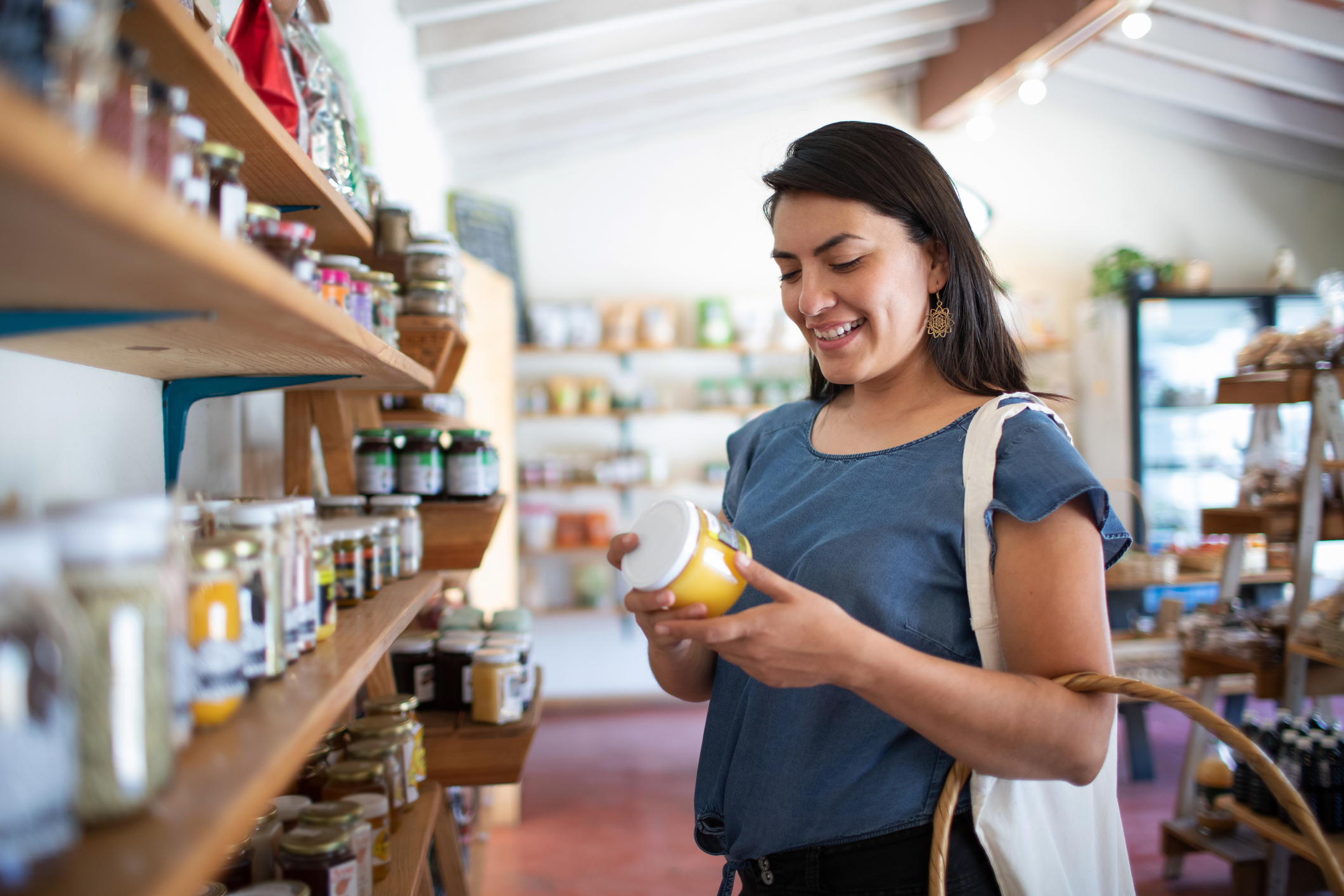 Young woman smiling buying healthy, artisanal food at small local store