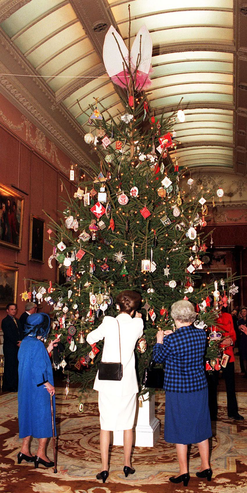 THE QUEEN LOOKS AT CHRISTMAS TREE AT BUCKINGHAM PALACE.