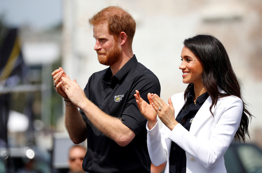 Britain's Prince Harry and Meghan, Duchess of Sussex, applaud at the Invictus Games Sydney 2018 Jaguar Land Rover Driving Challenge on Cockatoo Island, Sydney