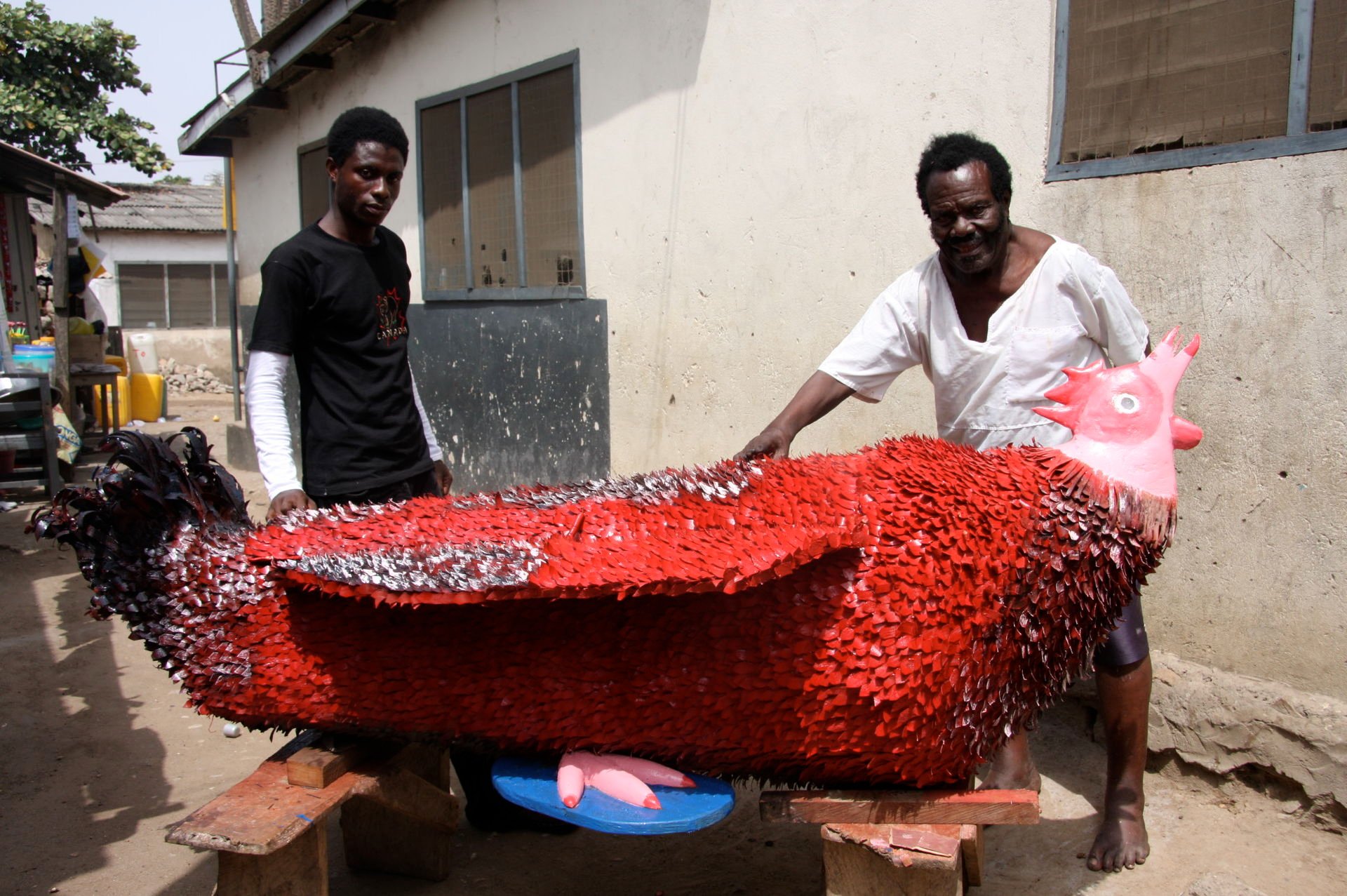 Ataa_Oko_and_Kudjo_Affutu_with_Okos_red_coq_coffin_2009._Foto_Regula_Tschumi.jpg