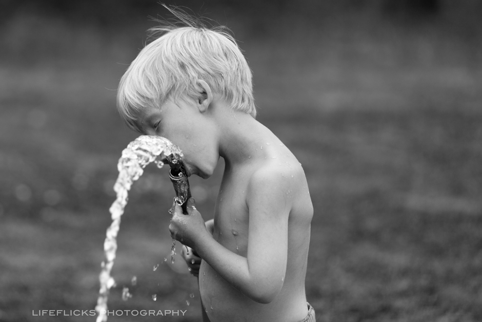 BlackWhiteBoyDrinkingWaterFromHose_CalgaryKidsPhotographer_LifeFlicksPhotography.jpg