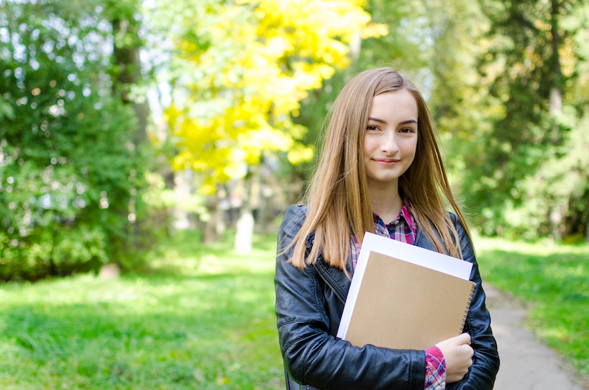 Teen girl outdoor holding books