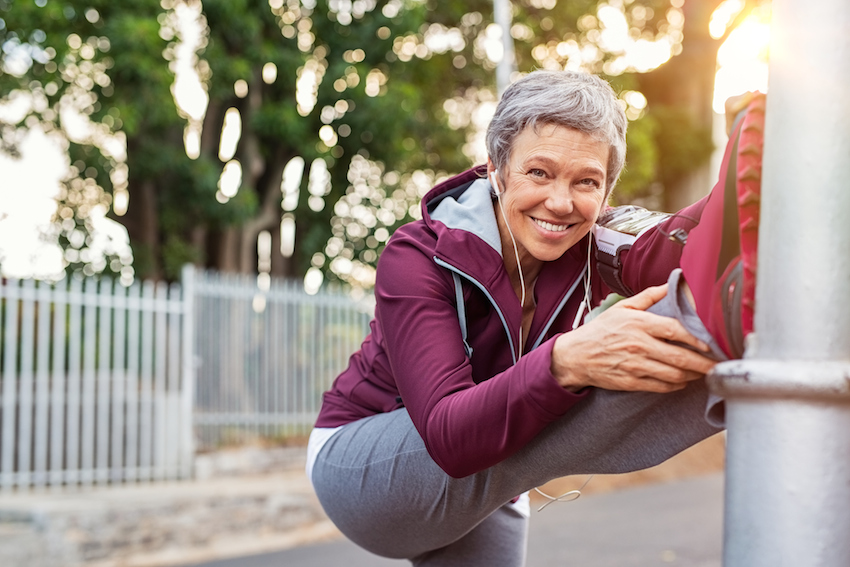 Mature woman warming up before jogging