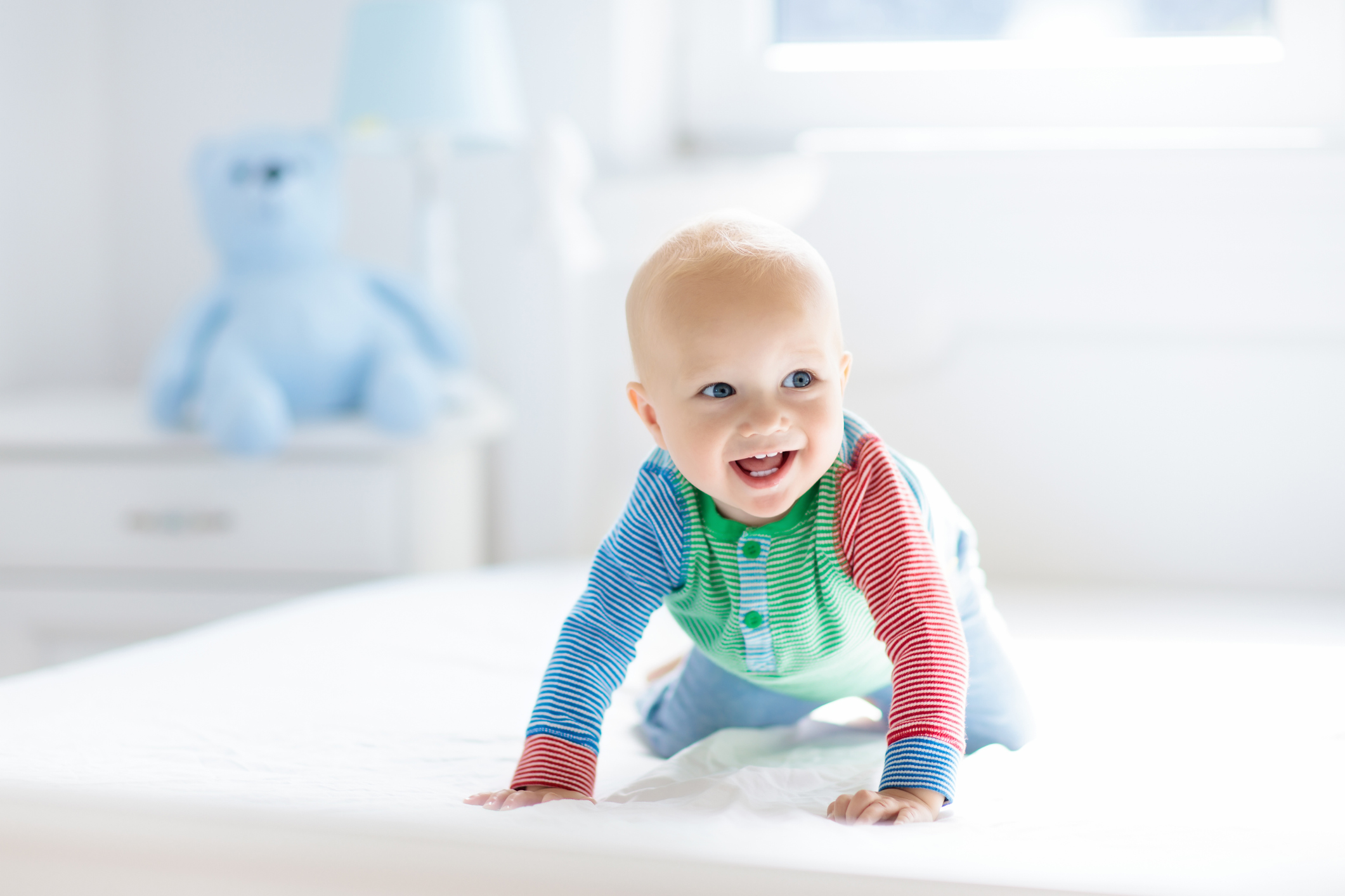 Baby boy crawling on bed