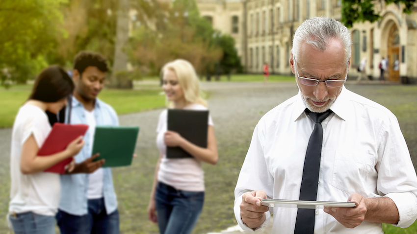 Senior male dean scrolling mobile app on tablet, technology in education
