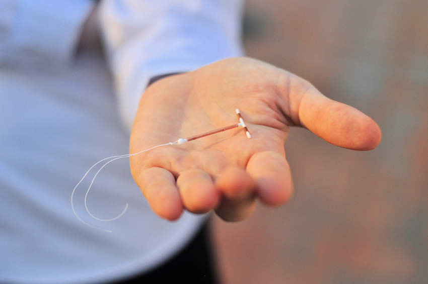 Holding an IUD birth control device in hand