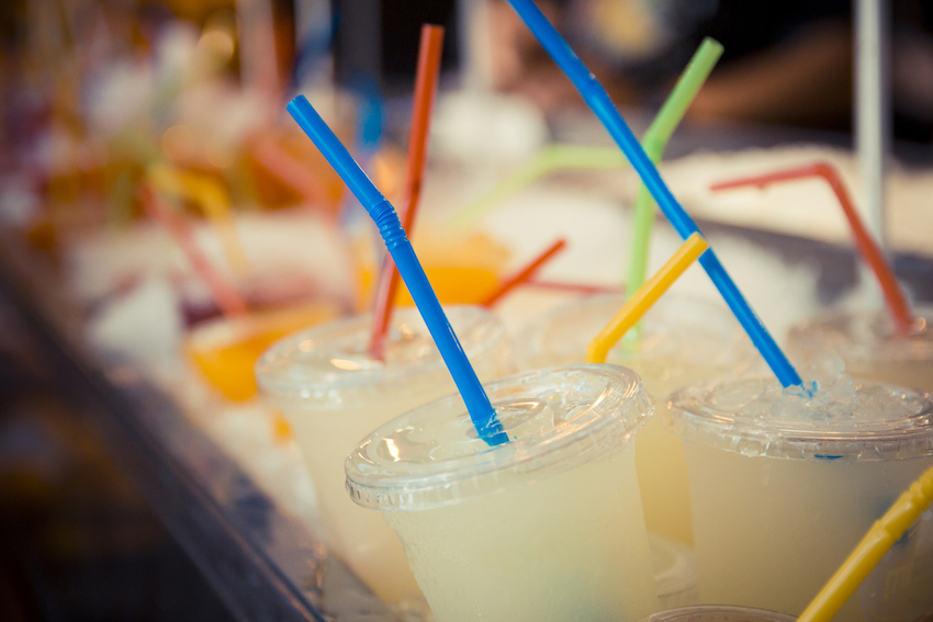 Selection of plastic cups with grapefruit juice and colored straws