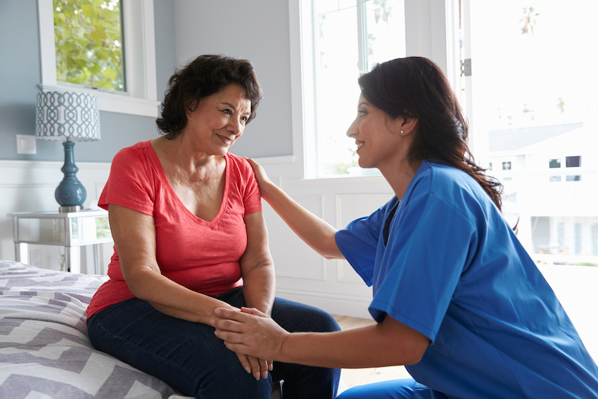 Nurse Making Home Visit To Senior Hispanic Woman