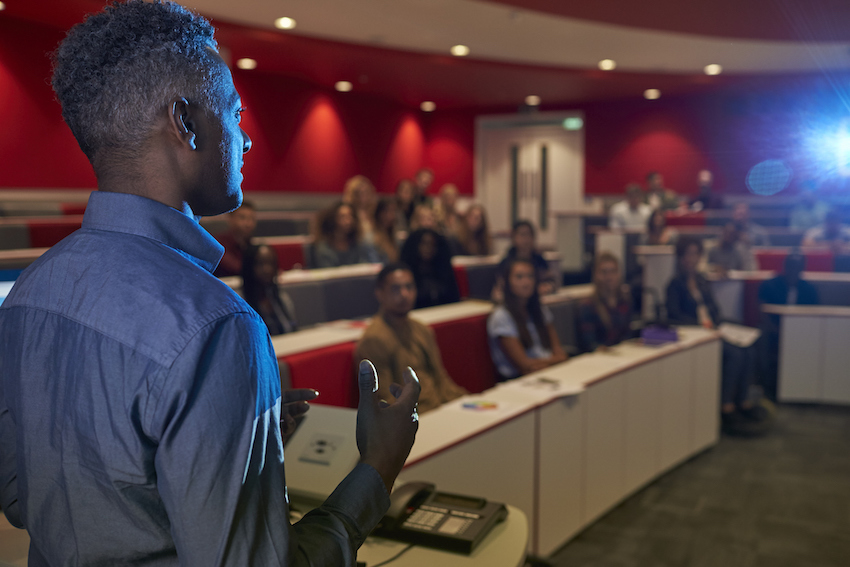 Man lecturing students in a university lecture theatre