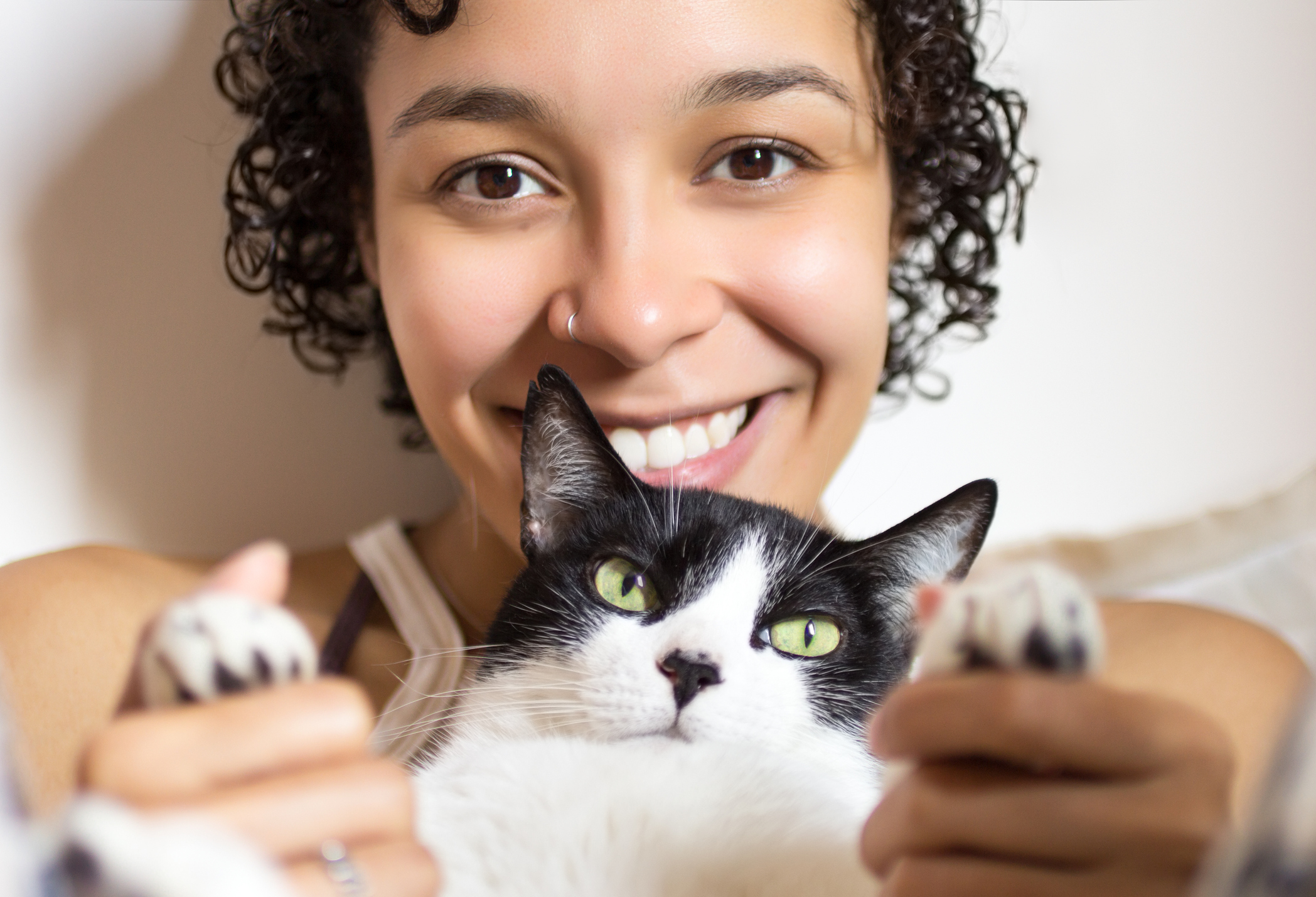 Young woman lying with cat and looking the camera