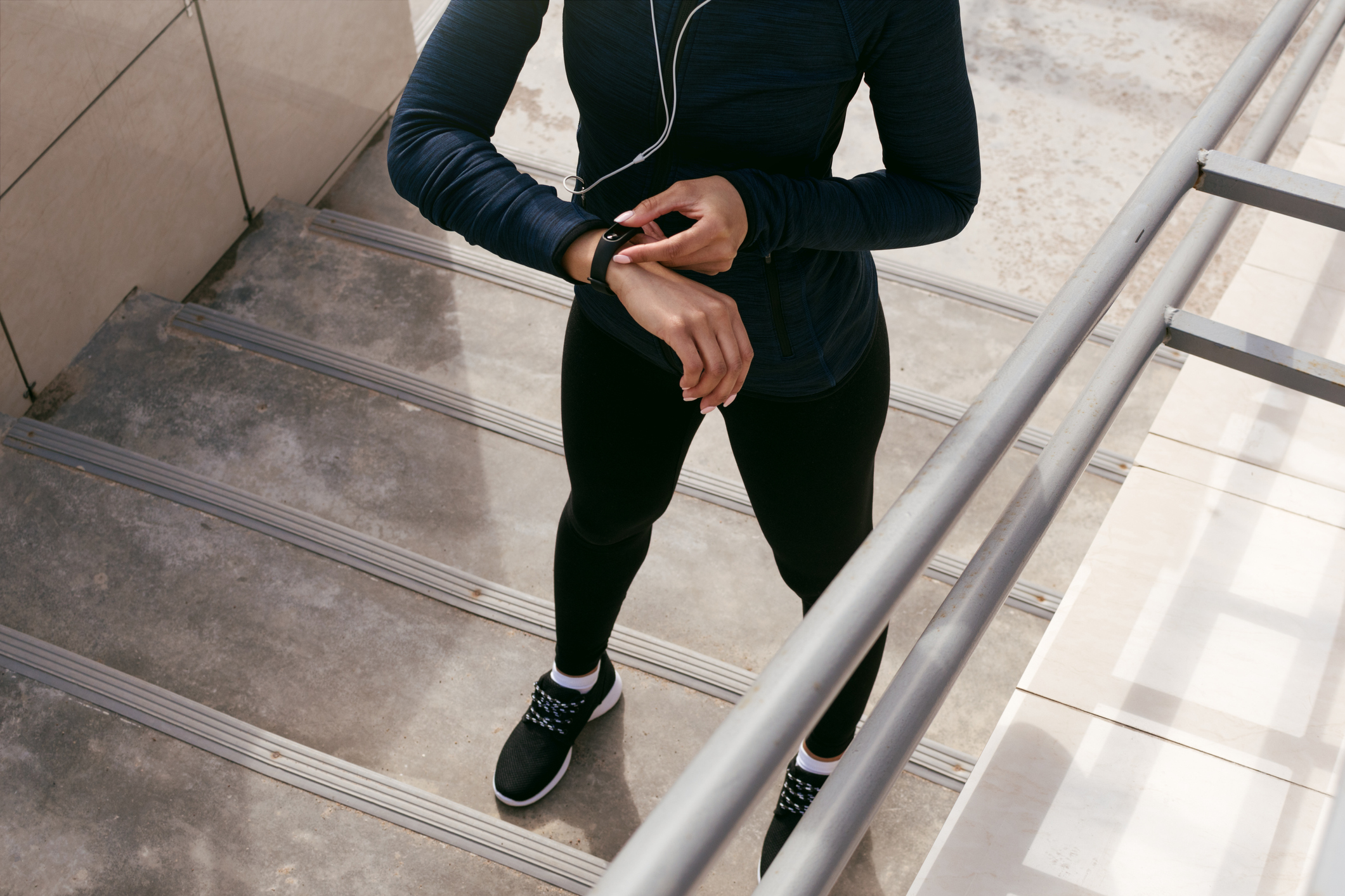 Unrecognizable female using fitness tracker after training