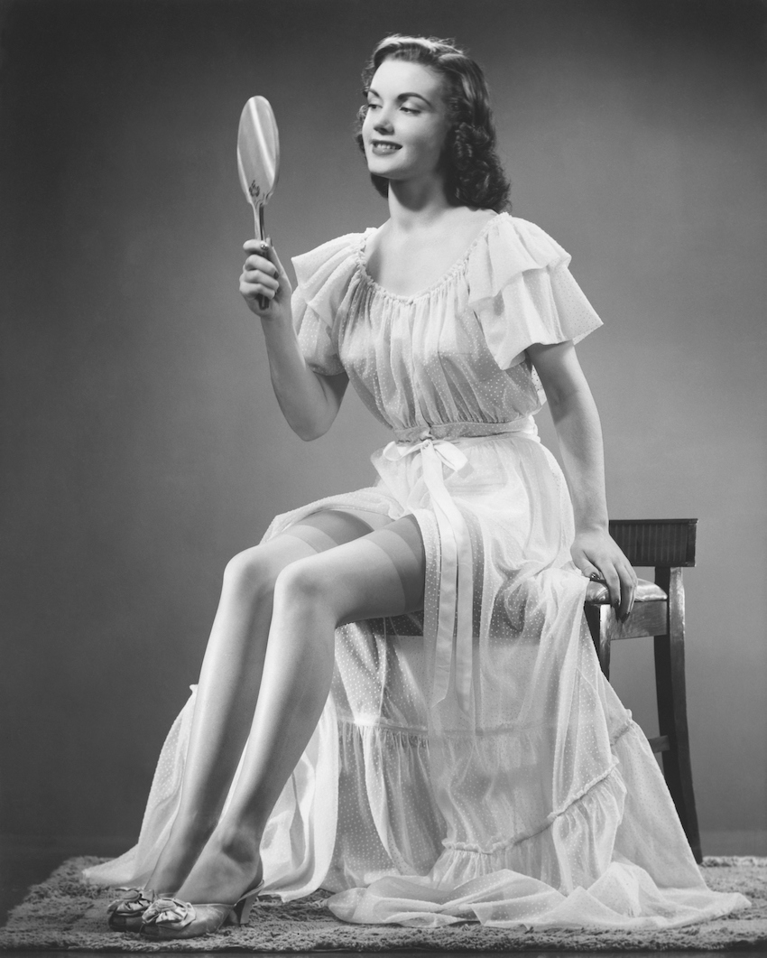 Woman looking at hand mirror (B&W)