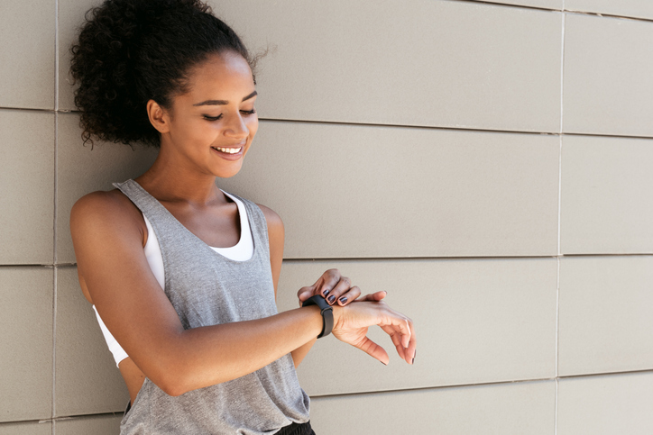 Fitness woman taking a break, checking activity tracker