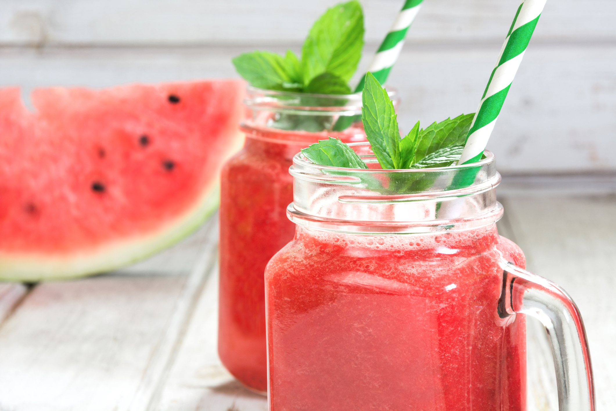 Summer refreshing detox smoothie of watermelon and mint on a white wooden background. Rustic style.