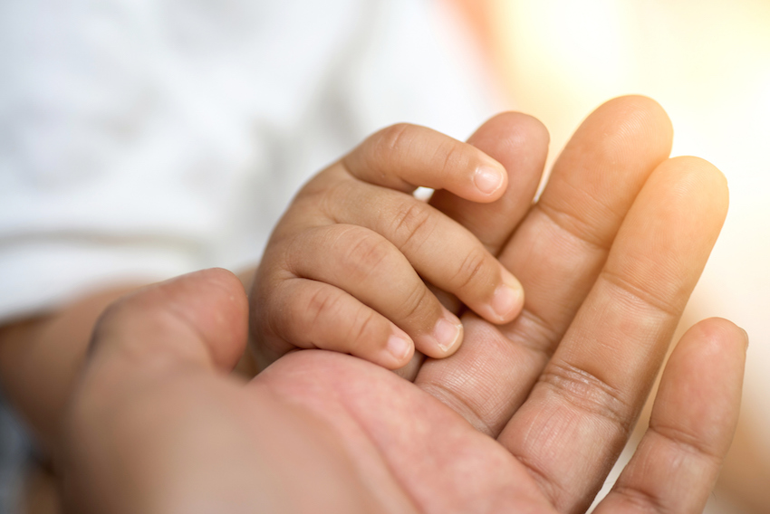 holding baby hand