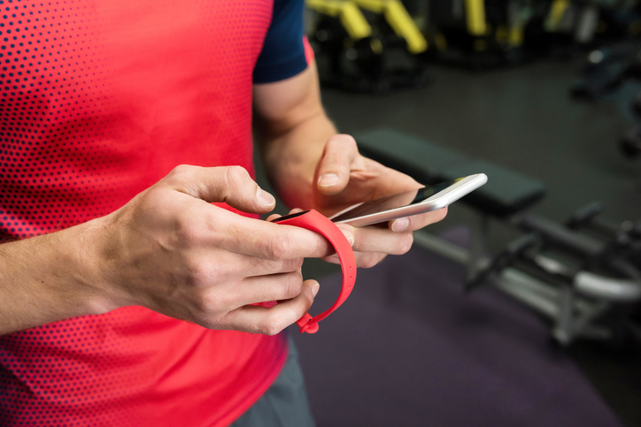 Sportsman using Fitness Device in Gym