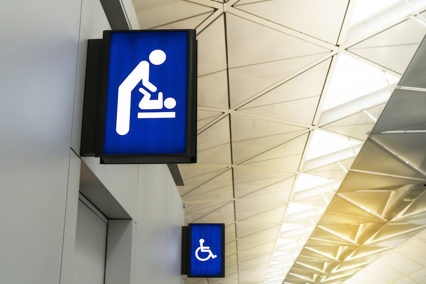 Illuminated signboard for deaper changing rooms and disabled toilet in international airport with copy space for text.