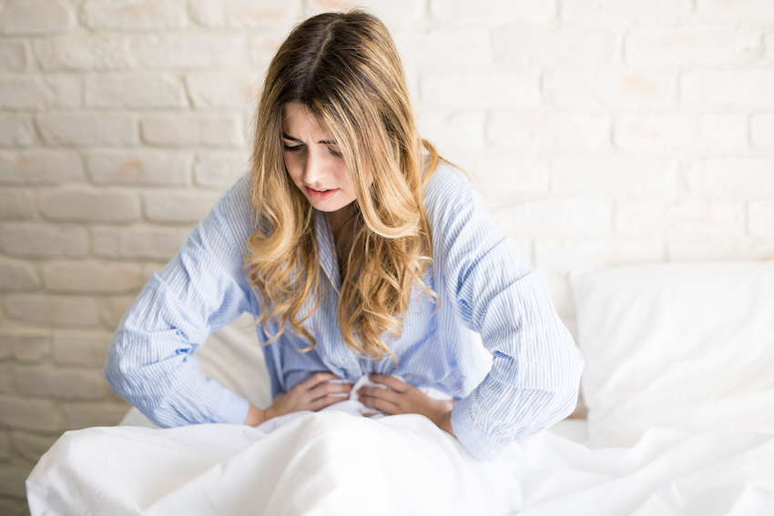 Woman waking up with stomachache