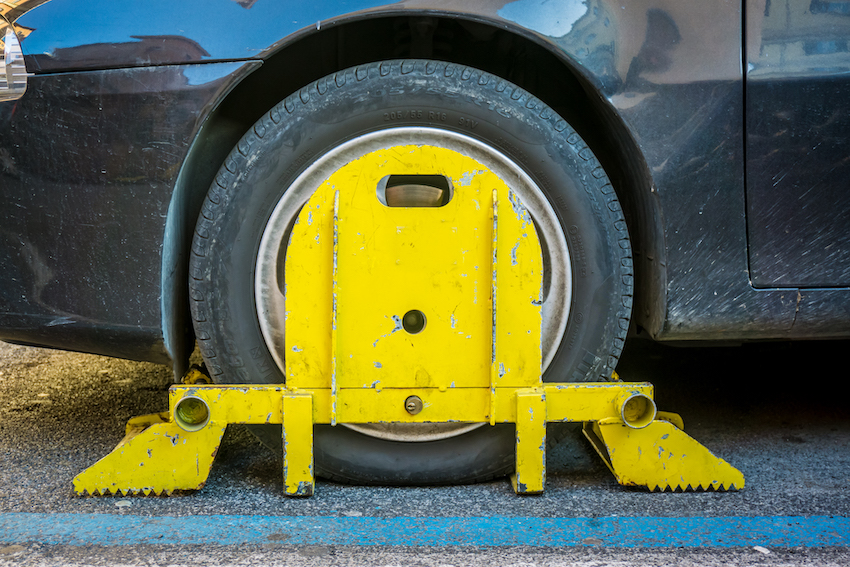 Clamped wheel of a car illegally parked in Rome,Italy