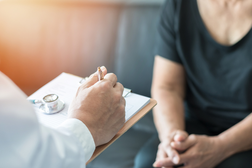 Geriatric doctor (geriatrician) consulting and diagnostic examining elderly senior adult patient (older person) on aging and mental health care in medical clinic office or hospital examination room