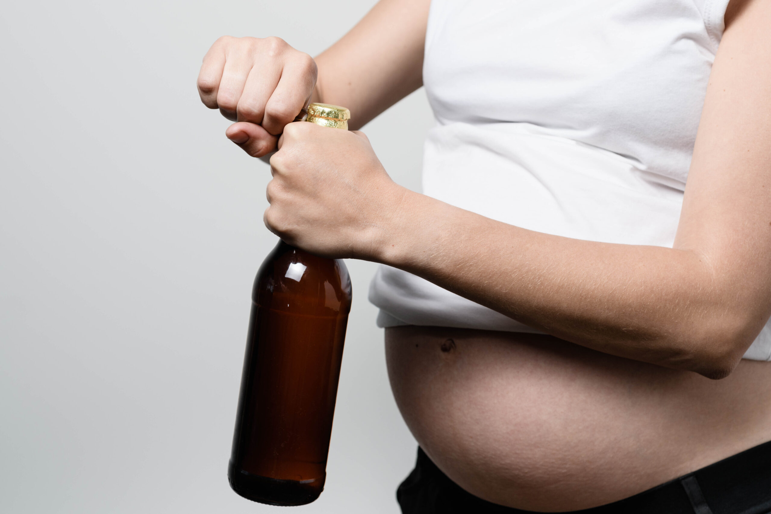Pregnant woman with beer bottle