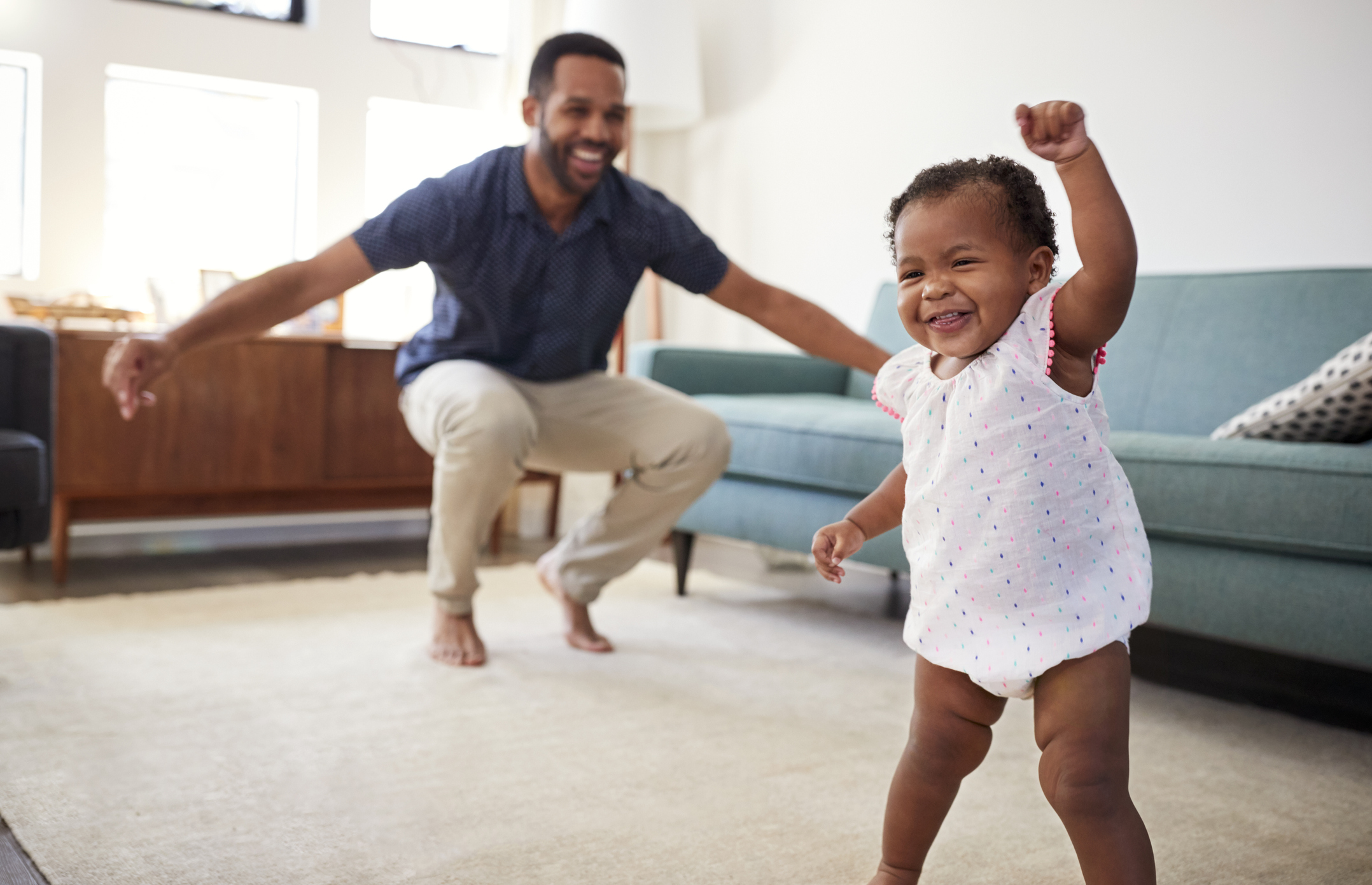 Baby Daughter Dancing With Father In Lounge At Home