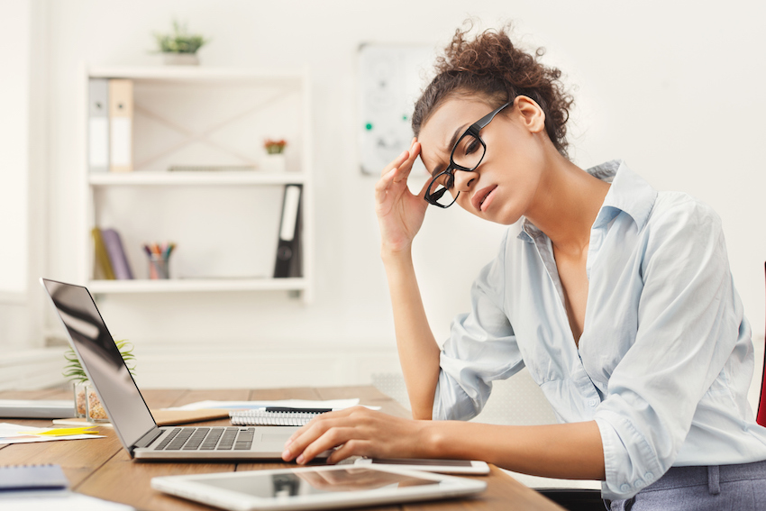 Frustrated business woman with headache at office