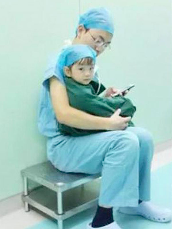 Heart-surgeon-comforts-crying-girl-by-playing-games-on-his-phone.jpg