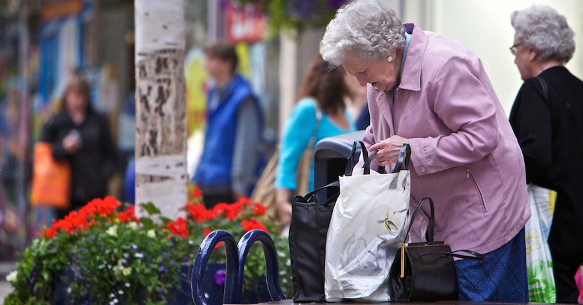 Old-lady-with-shopping-bags-on-busy-shopping-street