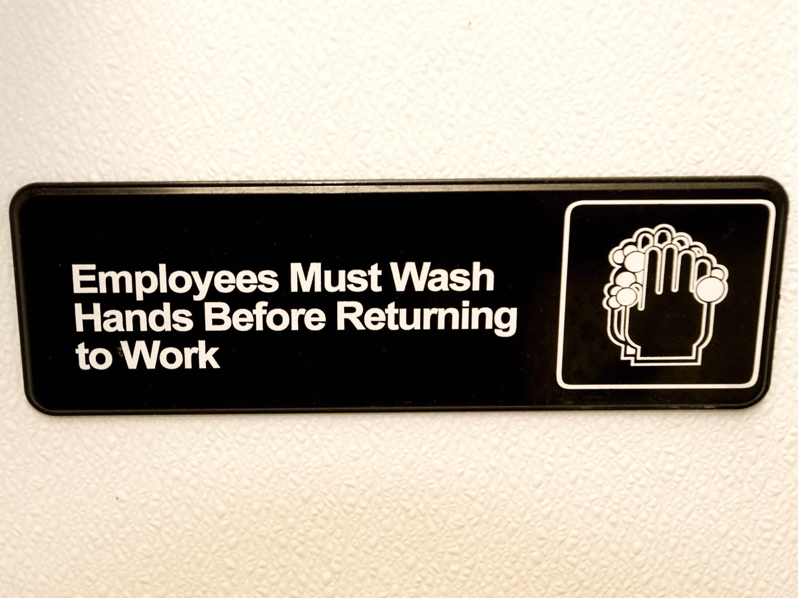 Sign with a simple graphic depicting two hands creating suds as