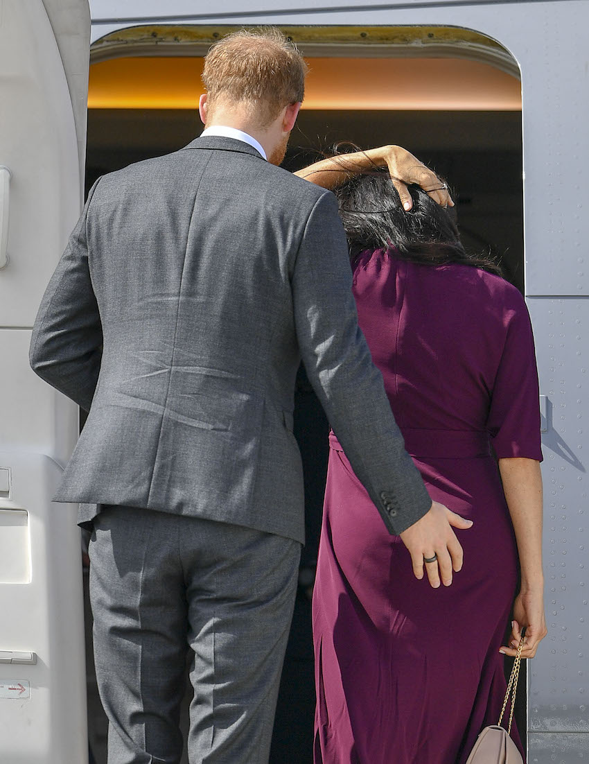 That's Cheeky! Prince Harry appears to usher his wife, Meghan Markle, into their RNZAF plane, with a pat on the bottom, as they depart Australia.
