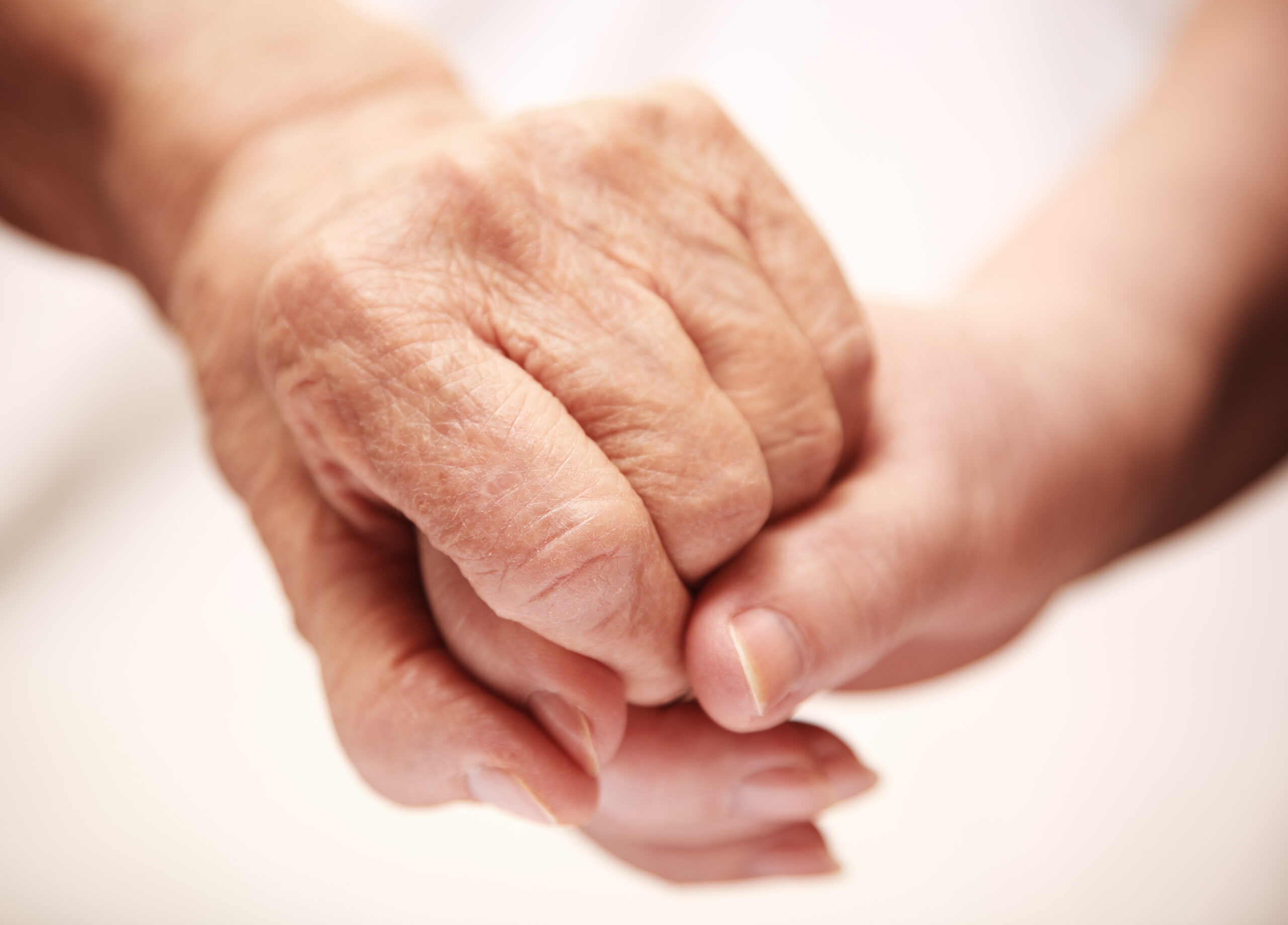 adult helping senior in hospital