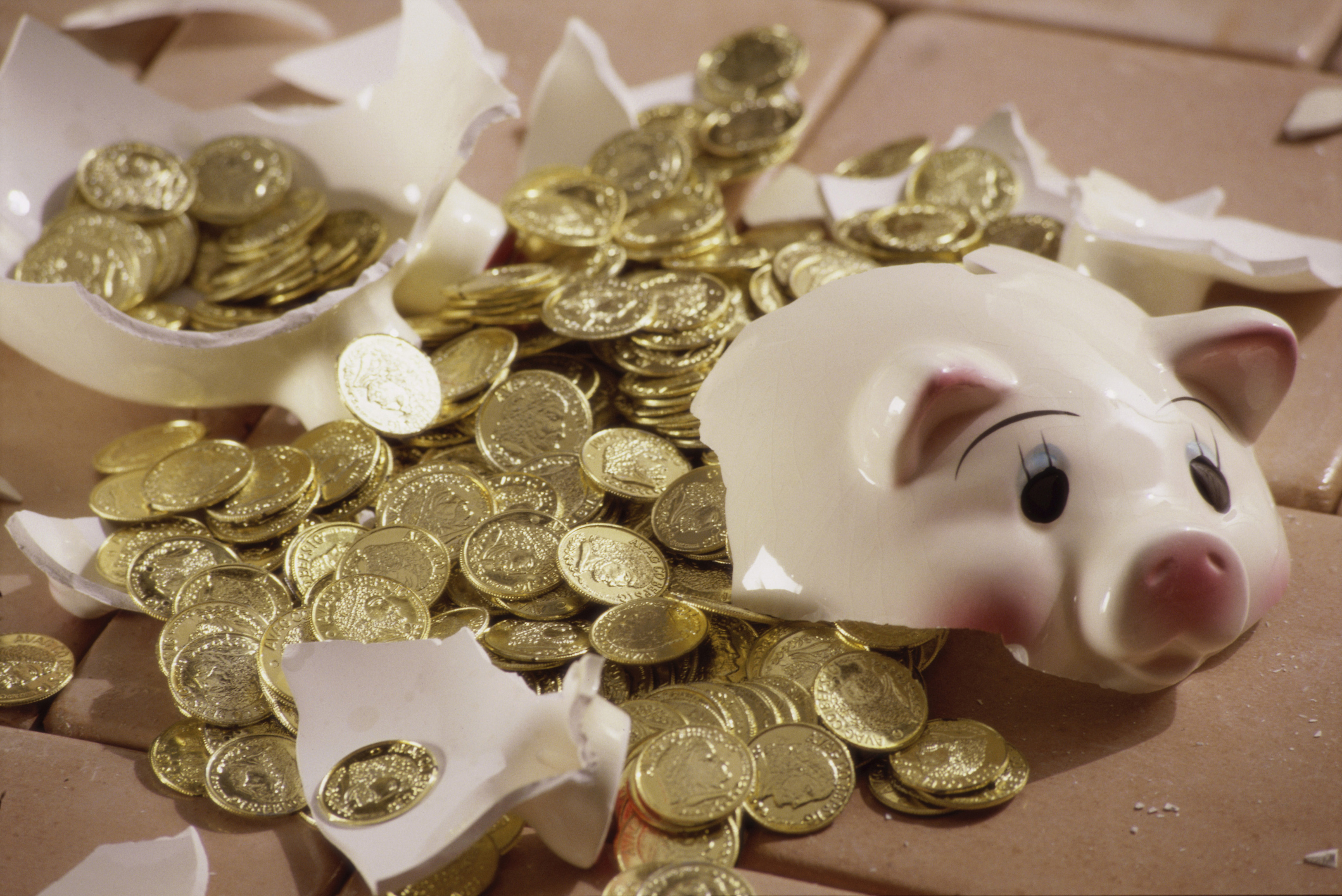 Broken piggy bank with coins