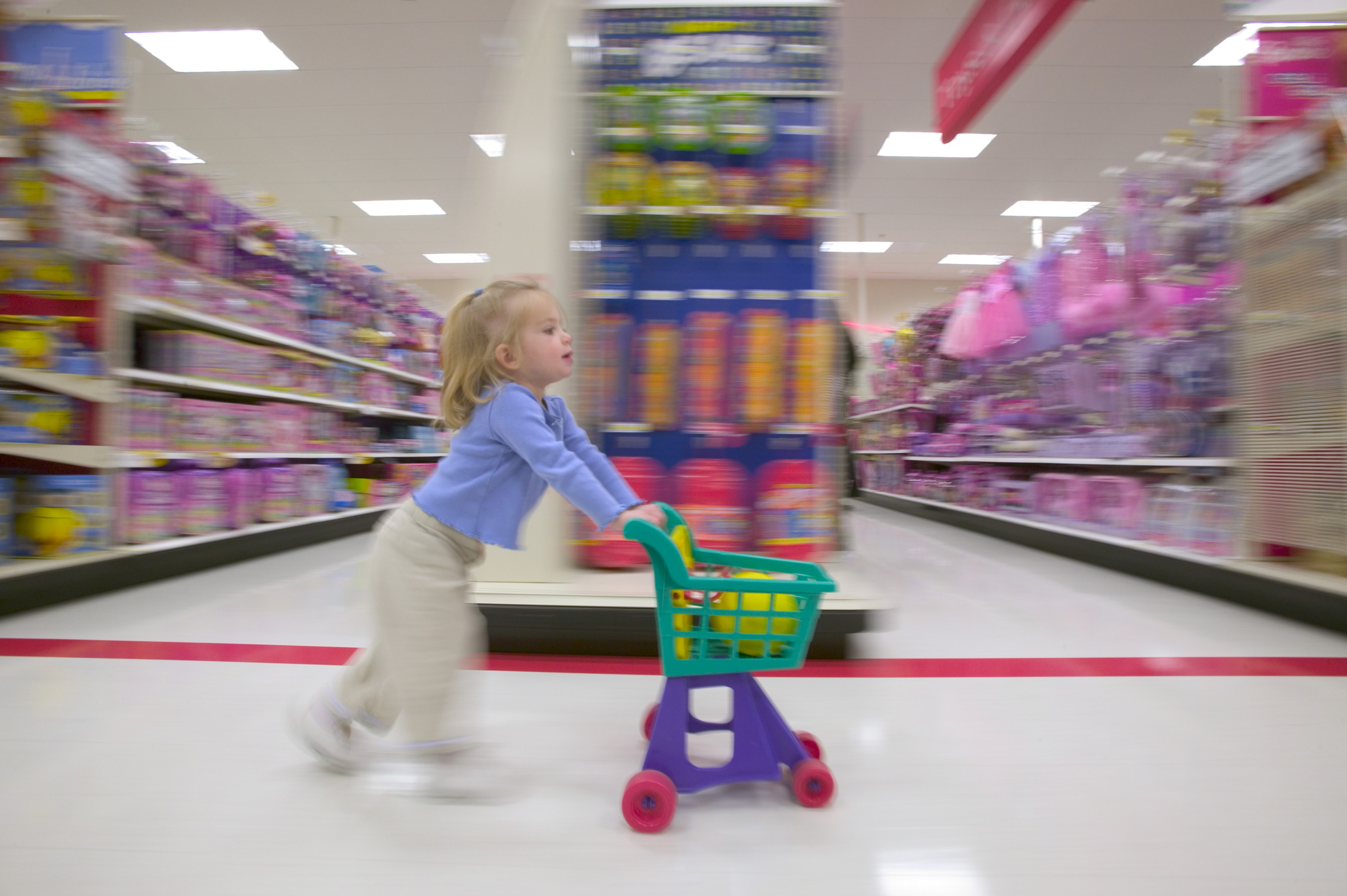 Side profile of a girl pushing a shopping cart in a supermarket