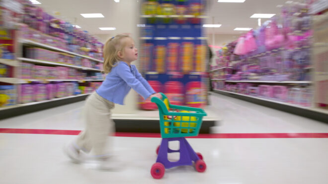 Side profile of a girl pushing a shopping cart in a supermarket