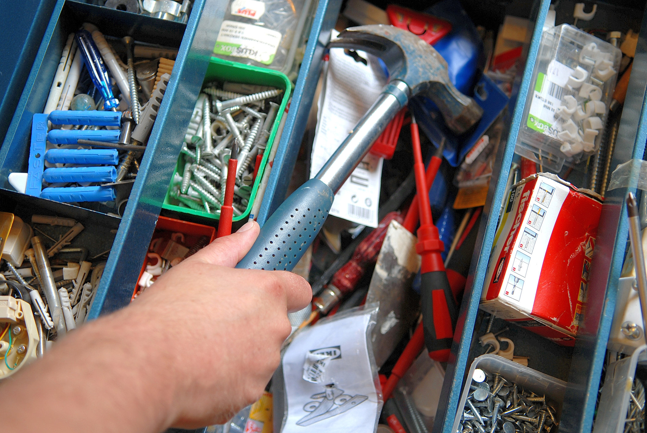 Person replacing hammer in toolbox