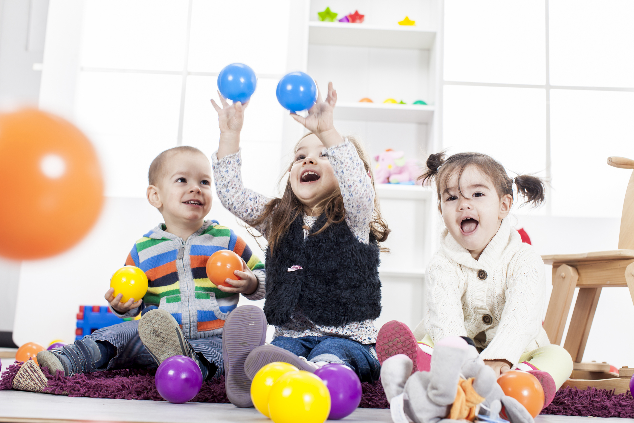 Children playing with colorful balls in room