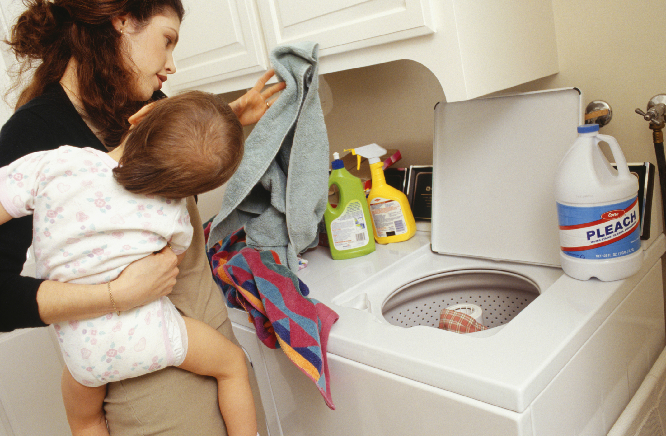 Mother and child (21-24 months) doing laundry