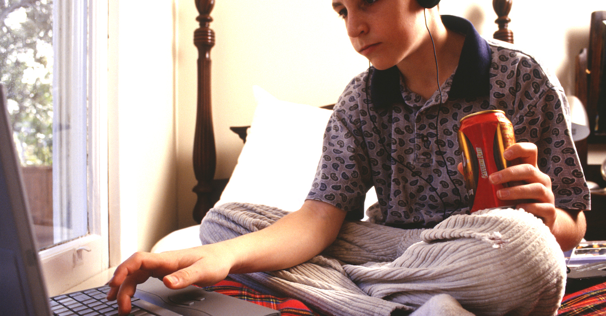 Teenage boy (16-17) using laptop