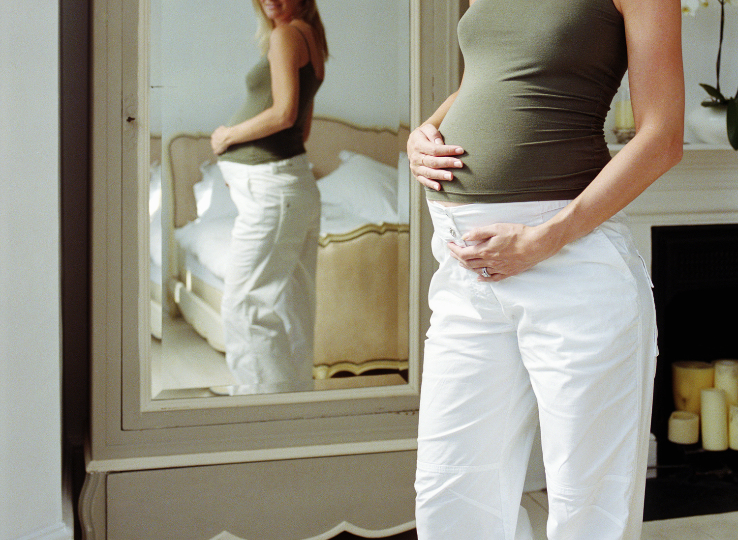 Pregnant woman looking at reflection in mirror