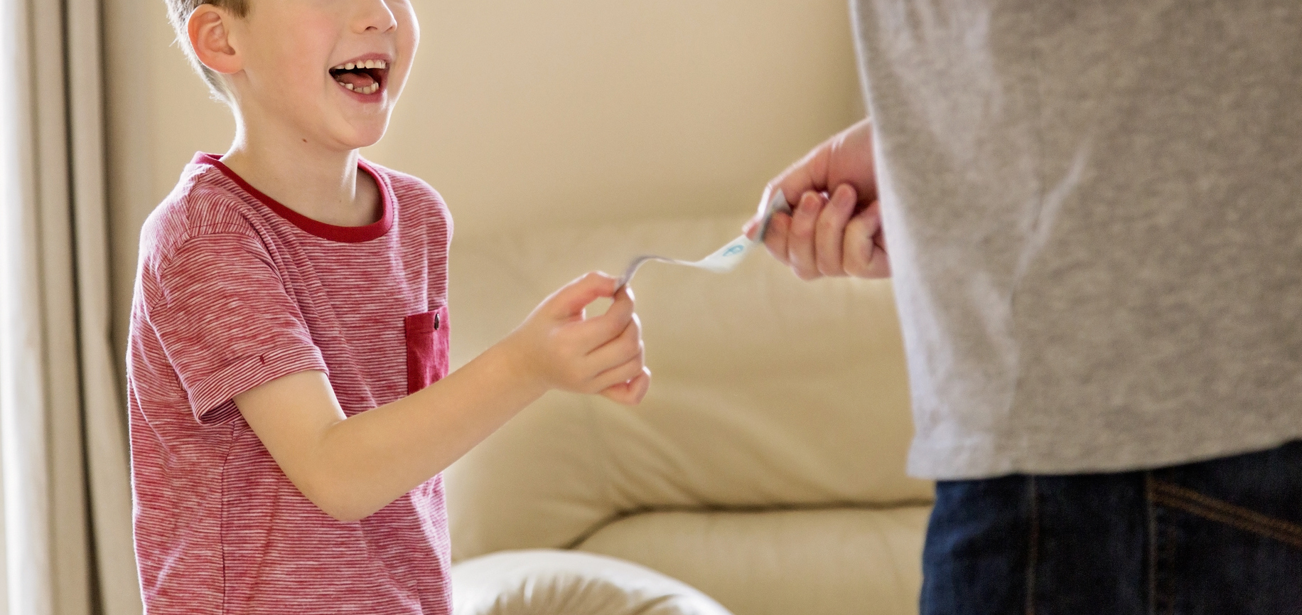 Boy receiving pocket money (allowance) from father