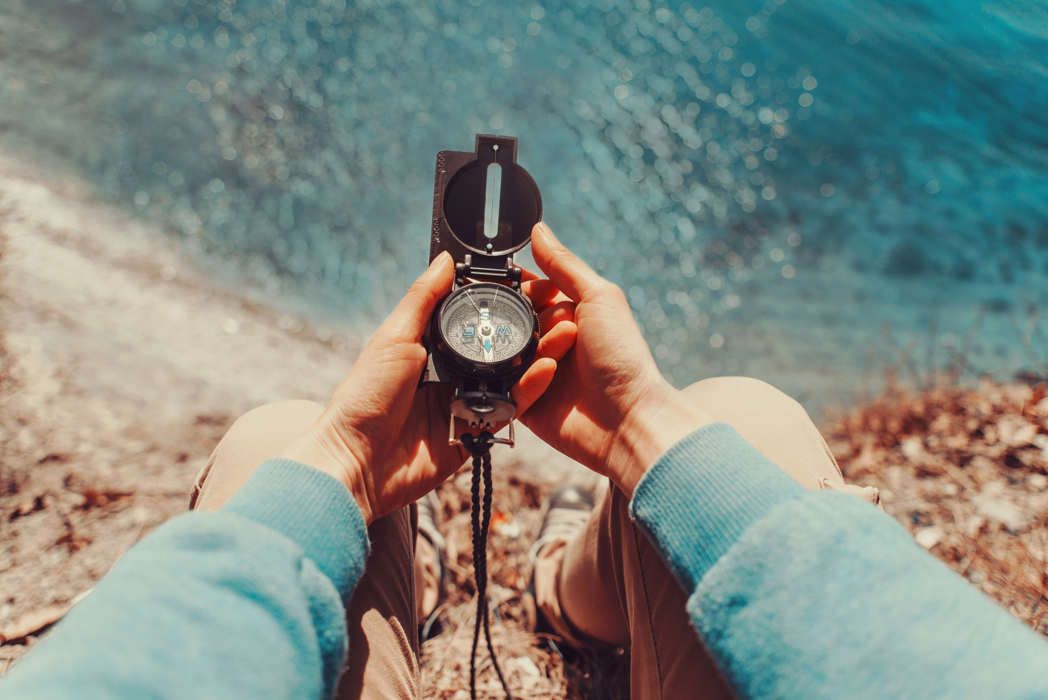 Traveler holding a compass on coastline Traveler holding a compass on coastline