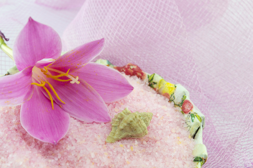 Pink lily flower with pink bath salt in decorated bowl