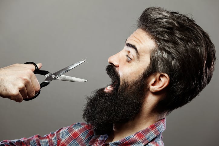 Man with long beard wearing undershirt and holding scissors Man with long beard wearing undershirt and holding scissors