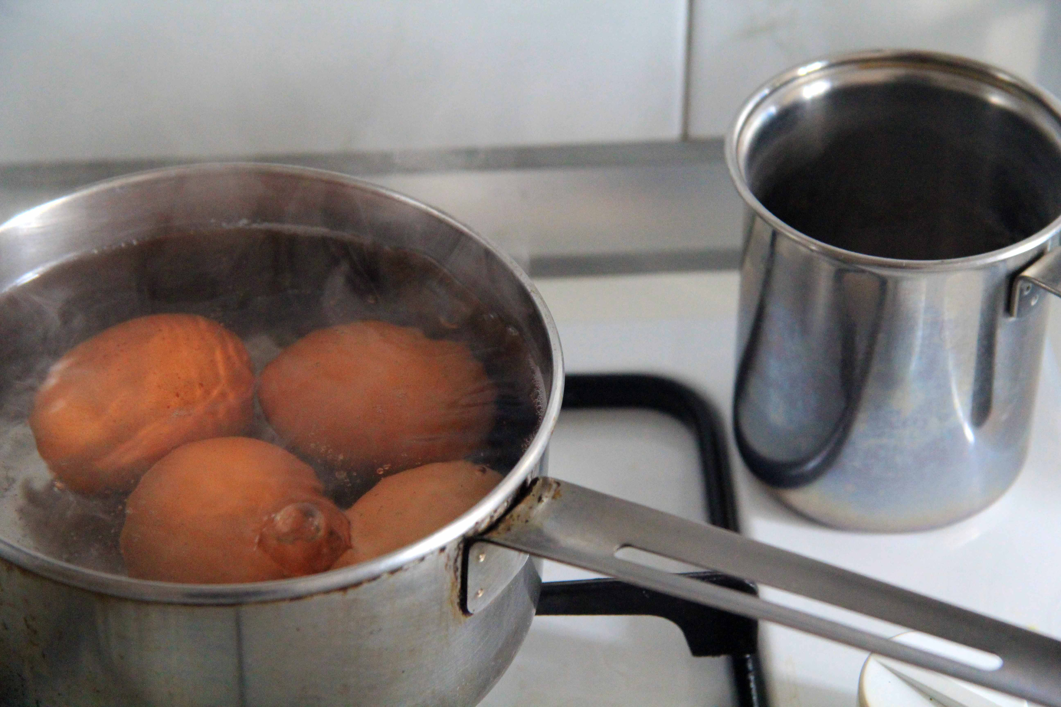 Eggs boiling in metal pot