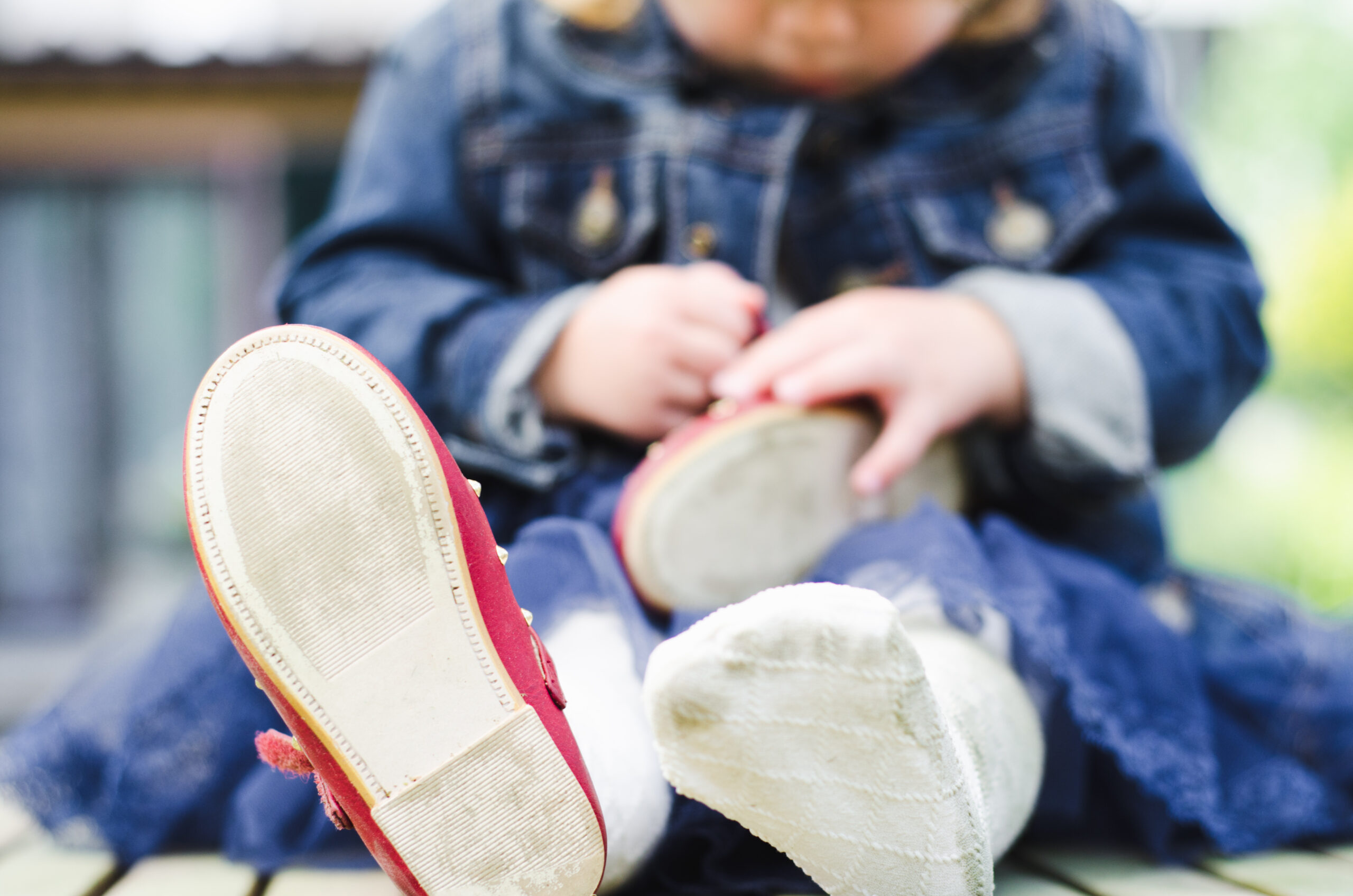 Baby girl plays with her shoes