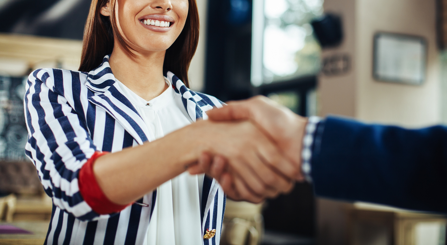 Businesswoman and businessman handshake in the cafe