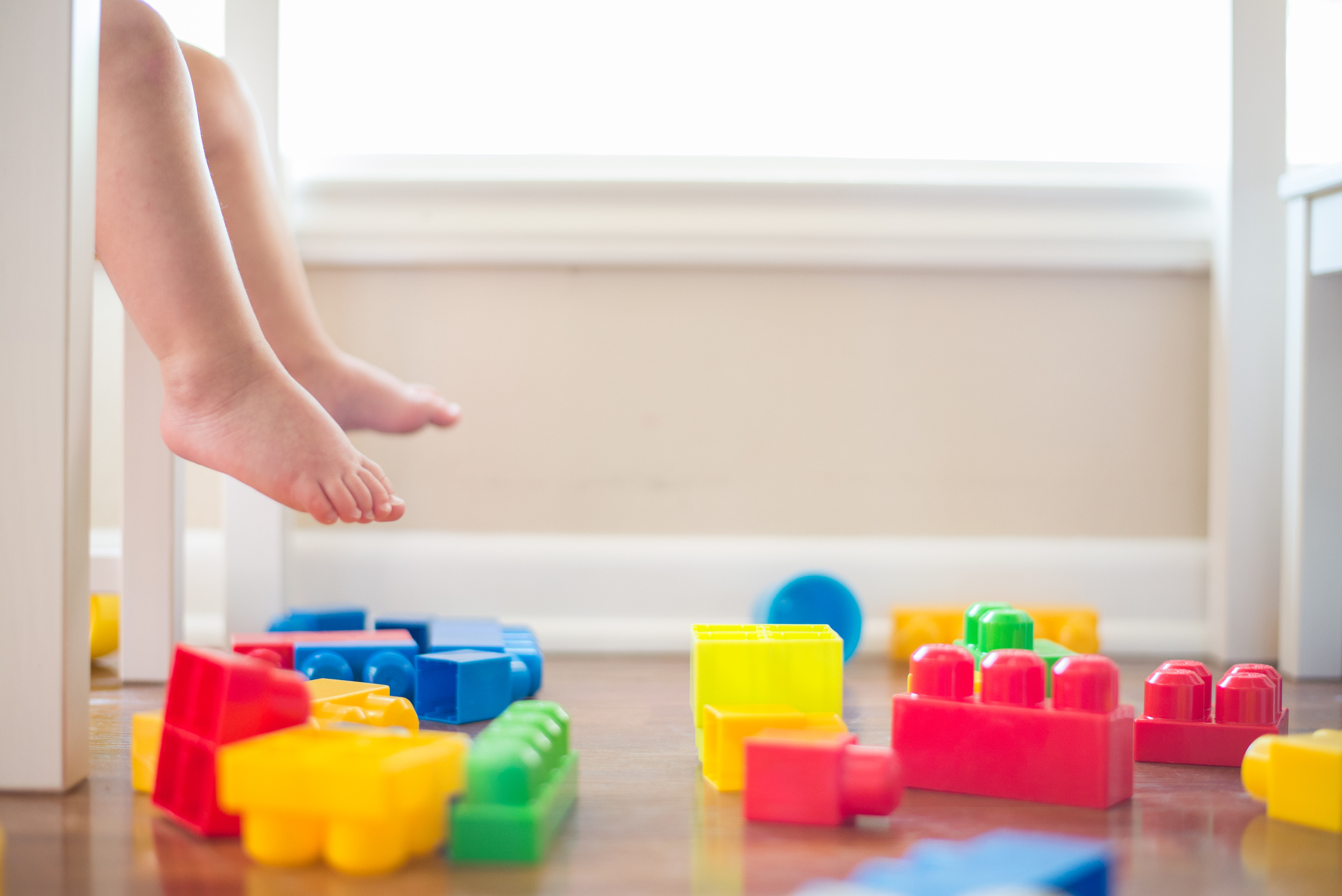 Toddler feet with blocks on the floor under a table