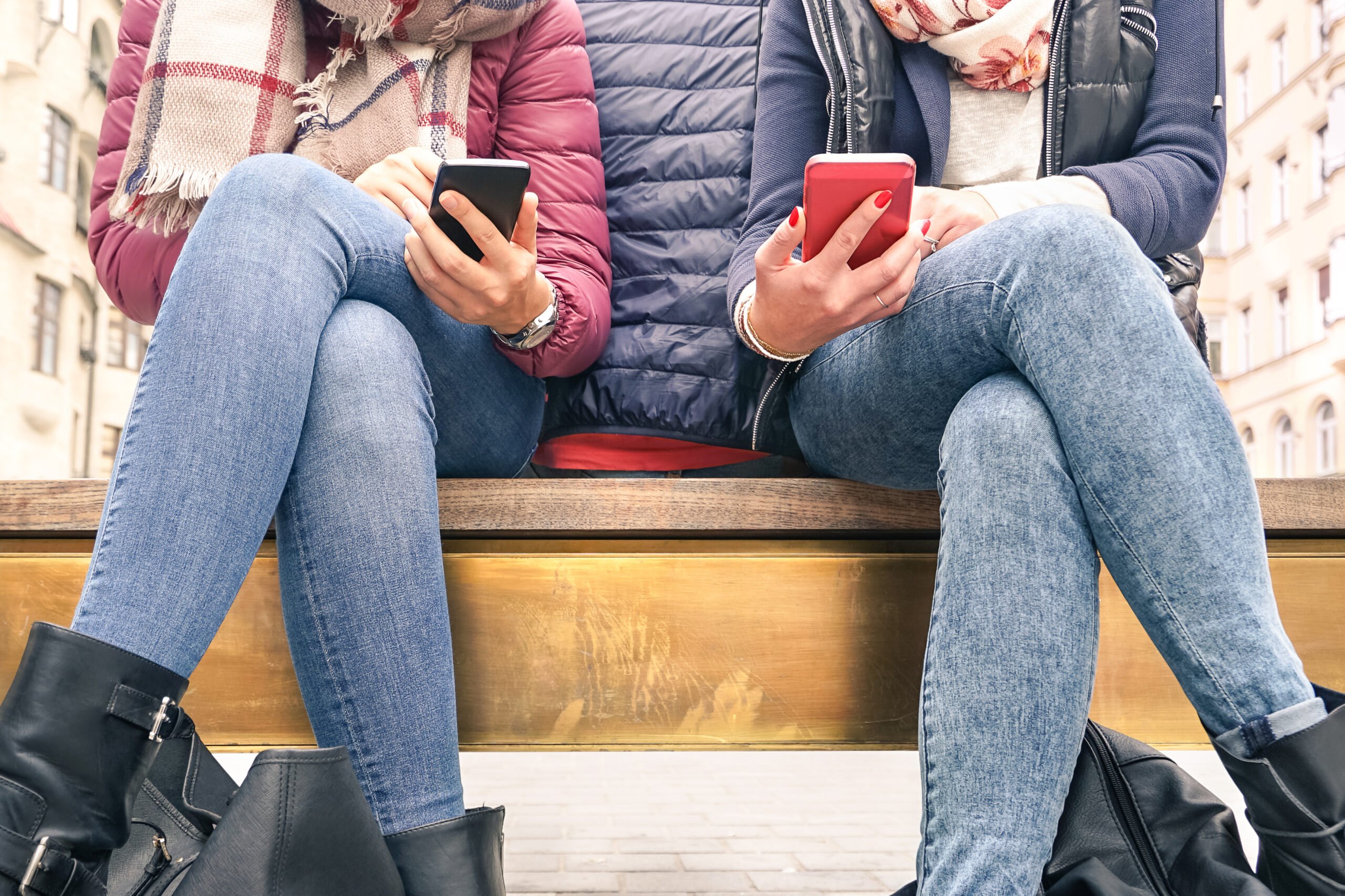 Couple of girlfriends in disinterest moment with mobile cellphones