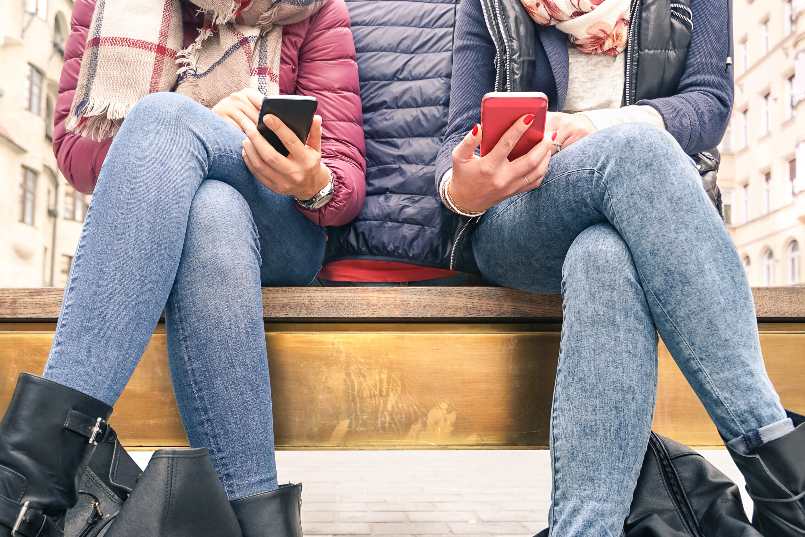 Couple of girlfriends in disinterest moment with mobile cellphones